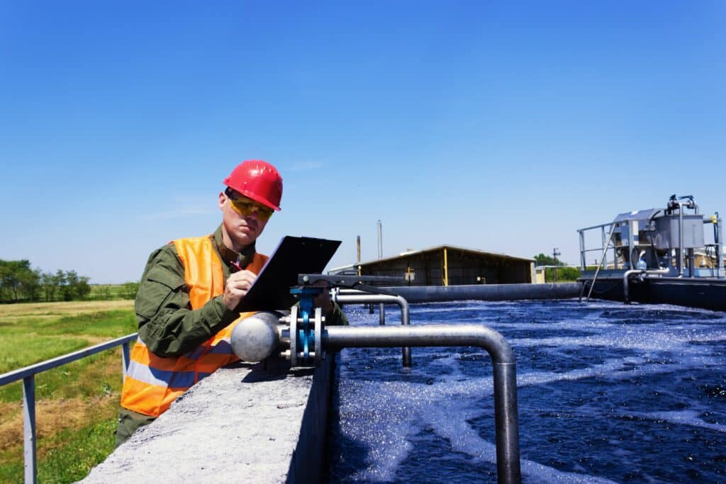 Worker inspecting valve for filtering water.