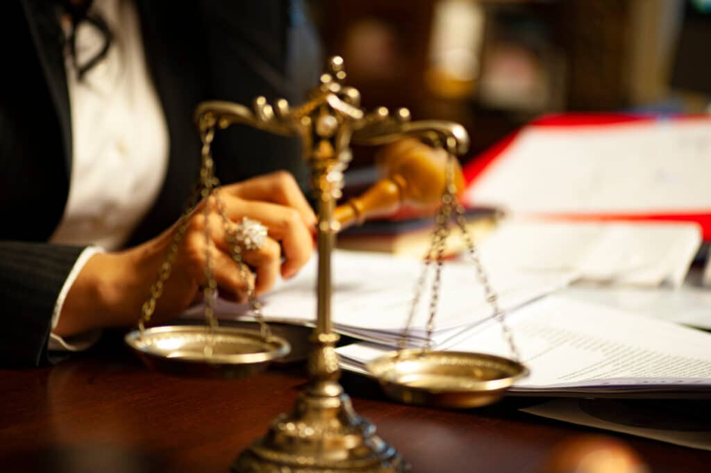 Dark haired female attorney signing documents.