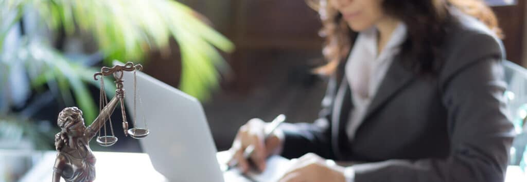 Woman in a business suit using a laptop.