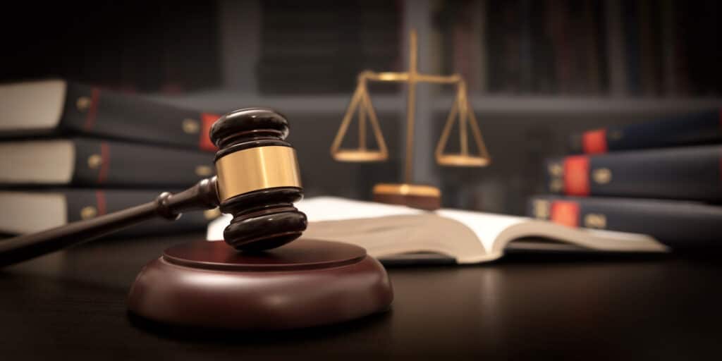 Gavel, book and scale on table in library