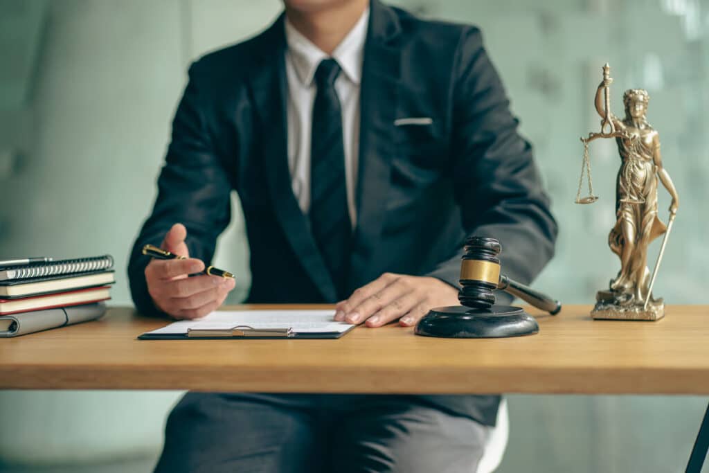 Lawyer sitting at a desk signing documents.