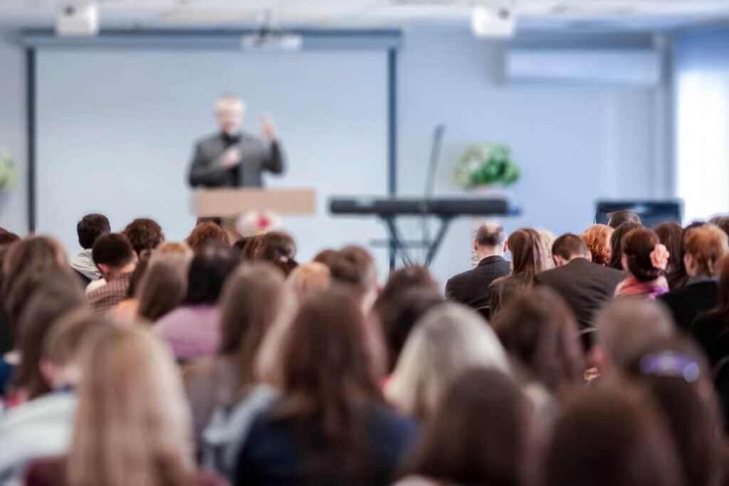 A man speaking in front of a group of people.