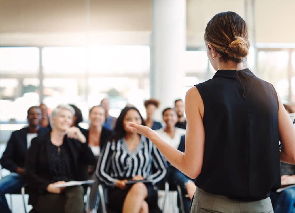 Back of a woman speaking to a group of people